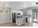 Bright kitchen with stainless appliances, granite counters, breakfast bar, and sliding doors to outdoor patio at 6525 Raven Hall St, North Las Vegas, NV 89084