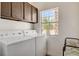 Bright laundry room with white machines and a view from the window at 6652 Coral Springs Cir, Las Vegas, NV 89108