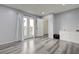 Bedroom with wood-look floors and french doors leading to balcony and desert landscaping at 7066 Burcot Ave # 59, Las Vegas, NV 89156