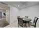 Bright dining area featuring tiled flooring, ceiling fan, and a modern round table with four chairs at 7066 Burcot Ave # 59, Las Vegas, NV 89156