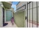 Exterior shot of a condo entrance with a purple bicycle parked by the door and an iron gate at 7066 Burcot Ave # 59, Las Vegas, NV 89156