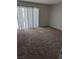 Spacious living room area featuring plush carpeting and sliding glass door access at 7426 Trudy Ln, Las Vegas, NV 89123