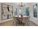 Dining room featuring round wood table, six chairs, modern lighting, and large windows at 7701 Sea Cliff Way, Las Vegas, NV 89128