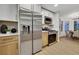 Bright kitchen featuring stainless steel refrigerator, microwave, and modern white and wood cabinets at 7701 Sea Cliff Way, Las Vegas, NV 89128