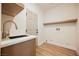Functional laundry room with modern sink, countertops, and wooden shelving at 9308 Pitching Wedge Dr, Las Vegas, NV 89134