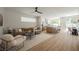 Open-concept living area boasts wood floors, modern decor, and seamless flow to kitchen and dining area at 9308 Pitching Wedge Dr, Las Vegas, NV 89134