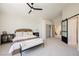 Serene bedroom features a ceiling fan, neutral carpet, and sliding barn door to the bathroom at 9308 Pitching Wedge Dr, Las Vegas, NV 89134