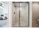 Elegant walk-in shower with glass door, marble tiles, and contrasting black fixtures at 9308 Pitching Wedge Dr, Las Vegas, NV 89134