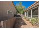 Narrow side yard with gravel landscaping, mature trees, and fencing on both sides at 9308 Pitching Wedge Dr, Las Vegas, NV 89134