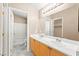 Bright bathroom featuring a double sink vanity, a large mirror, and a shower-tub combo at 9338 Square Dance Pl # 101, Las Vegas, NV 89178