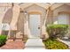 Charming front entrance featuring a white door, manicured landscaping, and colorful flowers at 9338 Square Dance Pl # 101, Las Vegas, NV 89178