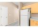 Efficient kitchen layout with white refrigerator and light wood cabinets at 9338 Square Dance Pl # 101, Las Vegas, NV 89178