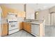 Well-equipped kitchen with white appliances, light wood cabinetry and stainless steel sink at 9338 Square Dance Pl # 101, Las Vegas, NV 89178
