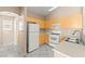 Cozy kitchen featuring neutral countertops, white appliances and wooden cabinetry at 9338 Square Dance Pl # 101, Las Vegas, NV 89178