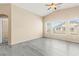 Bright living room featuring a ceiling fan, large windows, and modern gray flooring at 9338 Square Dance Pl # 101, Las Vegas, NV 89178