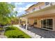 Inviting backyard with a covered patio, lush green lawn, and a decorative fire pit at 9373 Wild Lariat Ave, Las Vegas, NV 89178