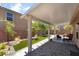 Covered patio with brick flooring, artificial grass, rock landscaping, and a fire pit at 9373 Wild Lariat Ave, Las Vegas, NV 89178