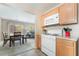 A cozy kitchen features wood cabinets, white appliances, and an adjacent dining area with natural light at 9373 Wild Lariat Ave, Las Vegas, NV 89178