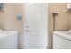 Laundry room with a white door and shelving above the washer and dryer at 9373 Wild Lariat Ave, Las Vegas, NV 89178