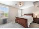 A comfortable bedroom with a large window, ceiling fan and a wooden bed with nightstands at 9373 Wild Lariat Ave, Las Vegas, NV 89178
