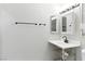 Bathroom featuring modern sink, faucet, mirrored medicine cabinet, towel rack, and bright white wall paint at 9572 Belle Rich St, Las Vegas, NV 89123