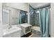 Modern bathroom featuring updated vanity, mosaic tiles, and bathtub with shower at 9572 Belle Rich St, Las Vegas, NV 89123