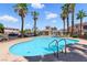 Beautiful community pool surrounded by palm trees, lounge chairs, and a pergola at 9572 Belle Rich St, Las Vegas, NV 89123