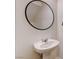Modern bathroom featuring a pedestal sink and round mirror at 10556 Sariah Skye Ave, Las Vegas, NV 89166