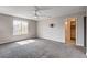 Bright primary bedroom boasts carpet, a ceiling fan, a TV mount, and natural light from the window at 10556 Sariah Skye Ave, Las Vegas, NV 89166