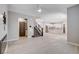 Spacious open-concept living room featuring stairs, kitchen, modern fireplace, and wood-look tile floors at 10556 Sariah Skye Ave, Las Vegas, NV 89166