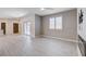 Bright, open living room featuring wood-look tile floors, modern fireplace, big window and an exterior door at 10556 Sariah Skye Ave, Las Vegas, NV 89166