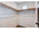 This is a walk-in closet with carpet, a small window and two rows of shelves at 10556 Sariah Skye Ave, Las Vegas, NV 89166