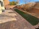 Paver patio and artificial grass make for a low-maintenance backyard at 10715 York Manor Ave, Las Vegas, NV 89166