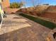 Backyard with brick-paved patio and turf area at 10715 York Manor Ave, Las Vegas, NV 89166
