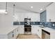 Modern kitchen featuring stainless steel appliances, white cabinets, and stylish blue backsplash at 116 Lotus Blossom Ct, Las Vegas, NV 89145