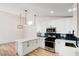 Bright, open kitchen featuring white cabinets, stainless steel appliances, and modern pendant lighting at 116 Lotus Blossom Ct, Las Vegas, NV 89145