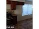 A charming kitchen featuring wooden cabinets, stainless steel oven, and a window letting in natural light at 1745 Starridge Way, Las Vegas, NV 89142