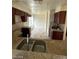 The kitchen features a double sink, brown cabinets, dark countertops, neutral backsplash, and tile flooring at 1745 Starridge Way, Las Vegas, NV 89142