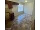 This kitchen features brown cabinets, dark countertops, neutral backsplash, and tile flooring at 1745 Starridge Way, Las Vegas, NV 89142