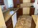 The kitchen features a stainless steel sink, brown cabinets, granite countertops, neutral backsplash, and tile flooring at 1745 Starridge Way, Las Vegas, NV 89142