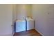 Convenient laundry room features laminate flooring and a white stacked washer and dryer at 1920 Lirio Way, Las Vegas, NV 89108