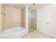 Bathroom showcasing a soaking tub and glass-enclosed shower, with modern fixtures and neutral tile at 200 W Sahara Ave # 2204, Las Vegas, NV 89102