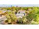 Aerial view of a home showcasing mature landscaping, multiple roofs, and the city skyline in the background at 226 Dalmatian Ln, Las Vegas, NV 89107