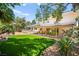 Expansive backyard with lush lawn, mature trees, covered patio, and manicured landscaping at 226 Dalmatian Ln, Las Vegas, NV 89107