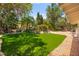Lush backyard featuring a waterfall feature, green lawn, and mature trees at 226 Dalmatian Ln, Las Vegas, NV 89107