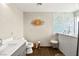 Updated bathroom featuring a marble-like accent wall, a sleek white vanity, and a modern toilet at 226 Dalmatian Ln, Las Vegas, NV 89107