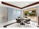 Dining room with a glass table, modern chairs, and a sliding glass door leading to the outdoor entertaining space at 226 Dalmatian Ln, Las Vegas, NV 89107