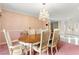 Elegant dining room with chandelier, pink carpet, and seating for six at 226 Dalmatian Ln, Las Vegas, NV 89107