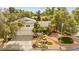 Exterior view showcases the front of the house, with a two-car garage, attractive landscaping, and mature trees at 226 Dalmatian Ln, Las Vegas, NV 89107