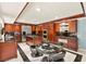 Open concept kitchen with dark wood cabinetry, stainless steel appliances, island cooktop, and a breakfast table at 226 Dalmatian Ln, Las Vegas, NV 89107